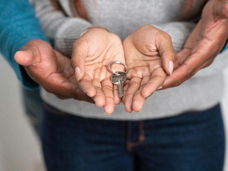 A man and a woman are holding a pair of keys in their hands.