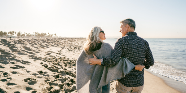 couple walking on beach talking about funeral planning