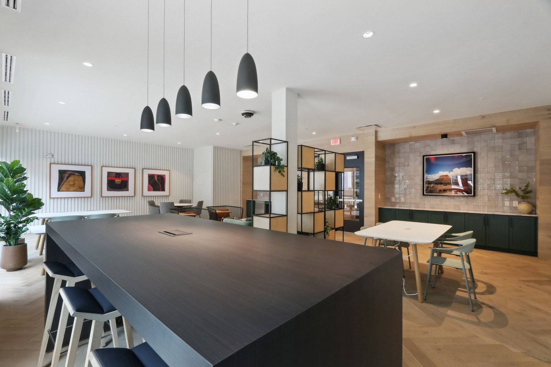 Modern apartment community lounge with a large dark island and seating.