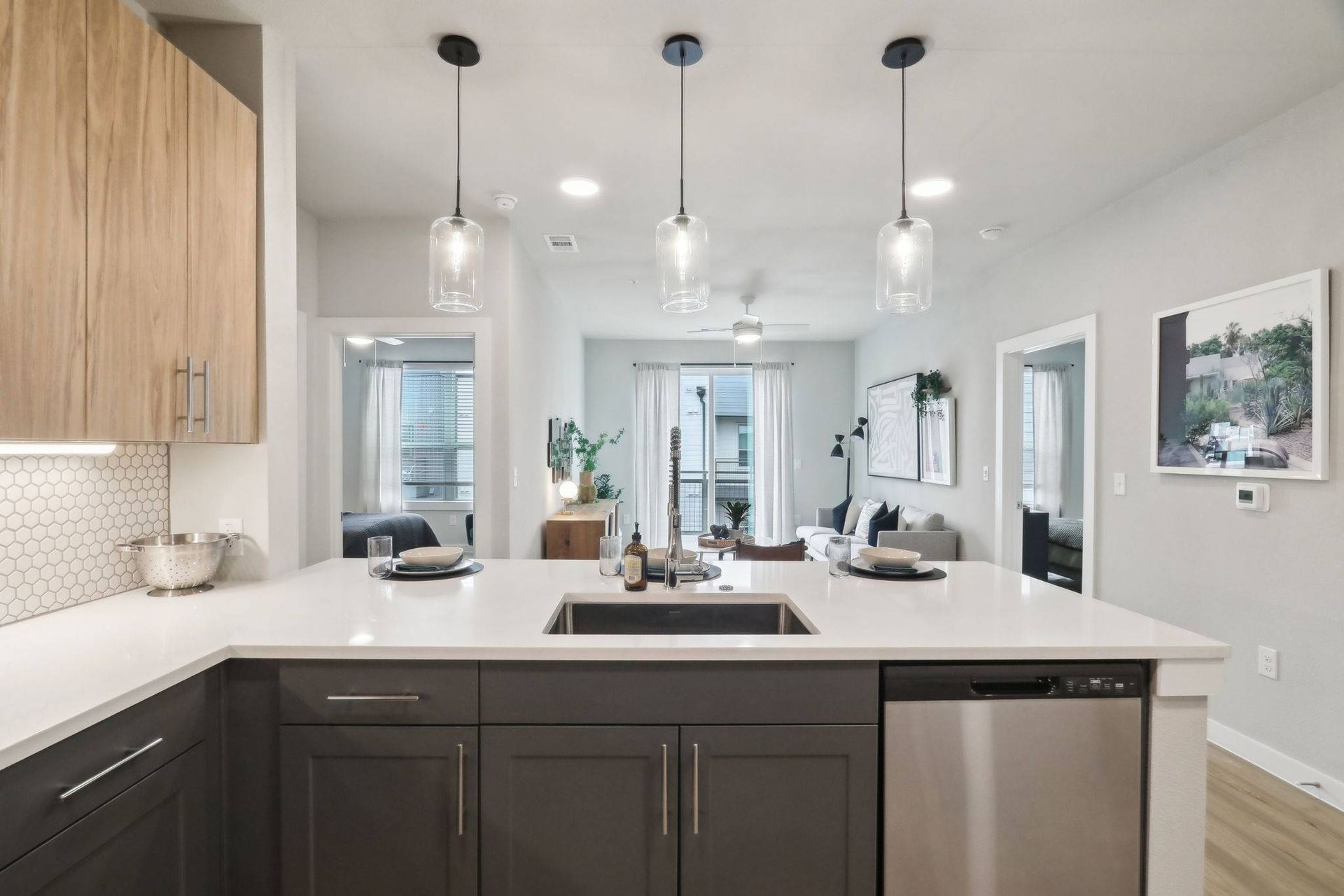 Open-concept kitchen with an island, sink, and pendant lights overlooking the living area.