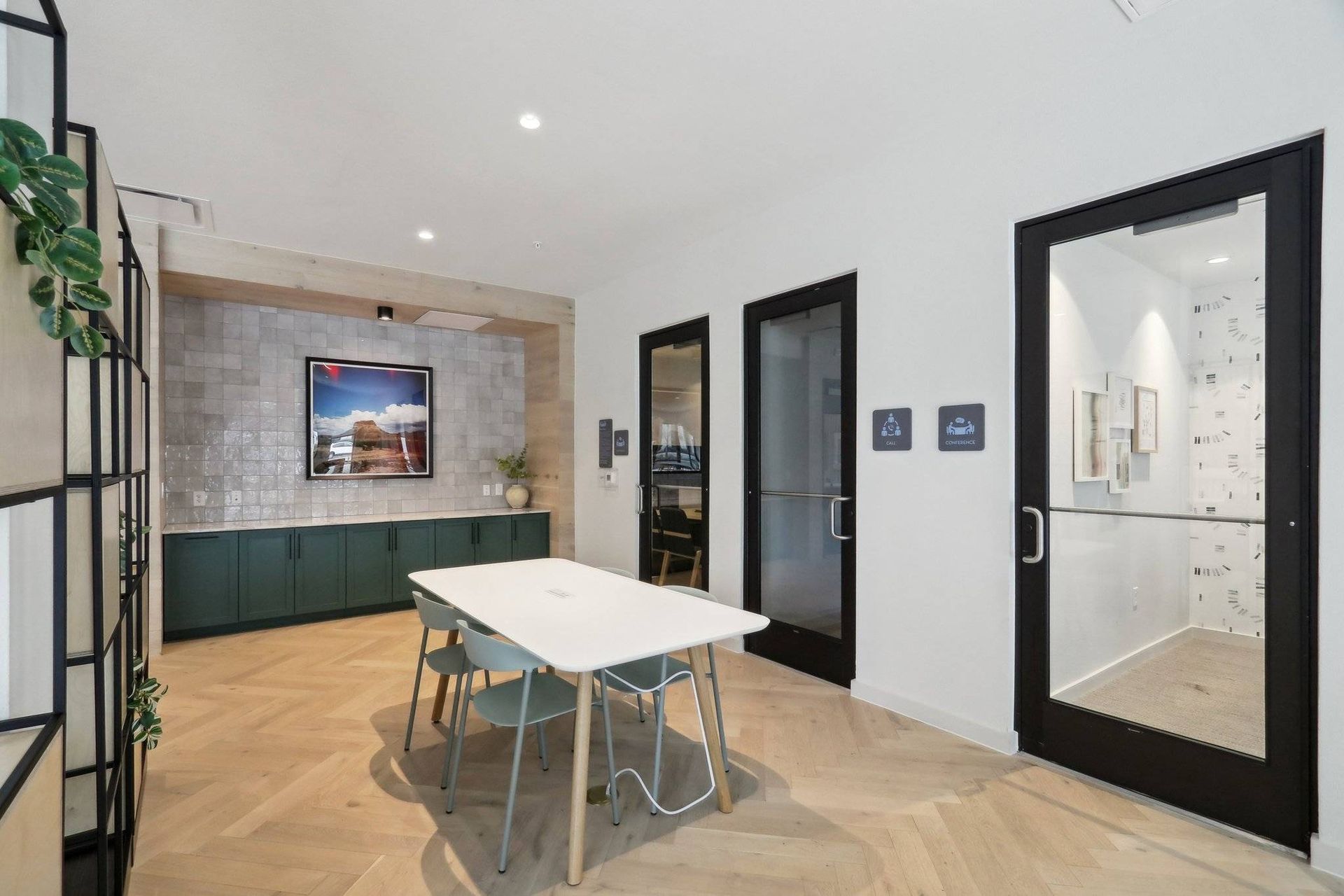 Lobby-style community room with a white table and teal cabinetry.