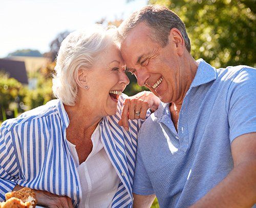 Elderly couple laughing and sitting outside