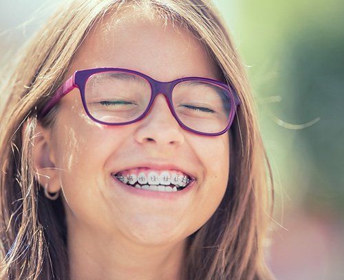 Young girl with traditional braces smiling