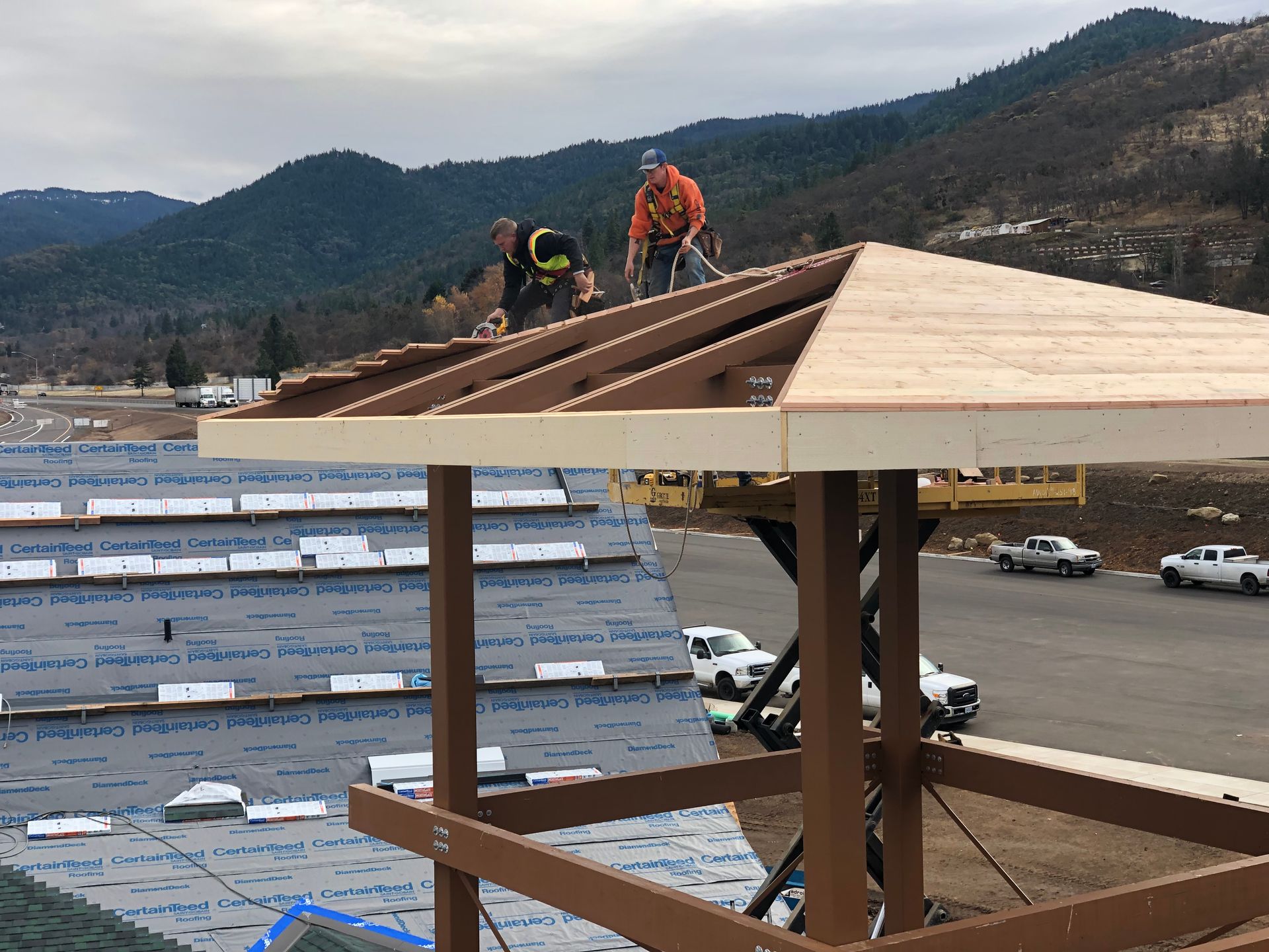 Modern building exterior with large glass windows reflecting the surroundings, and a dark, textured panel.