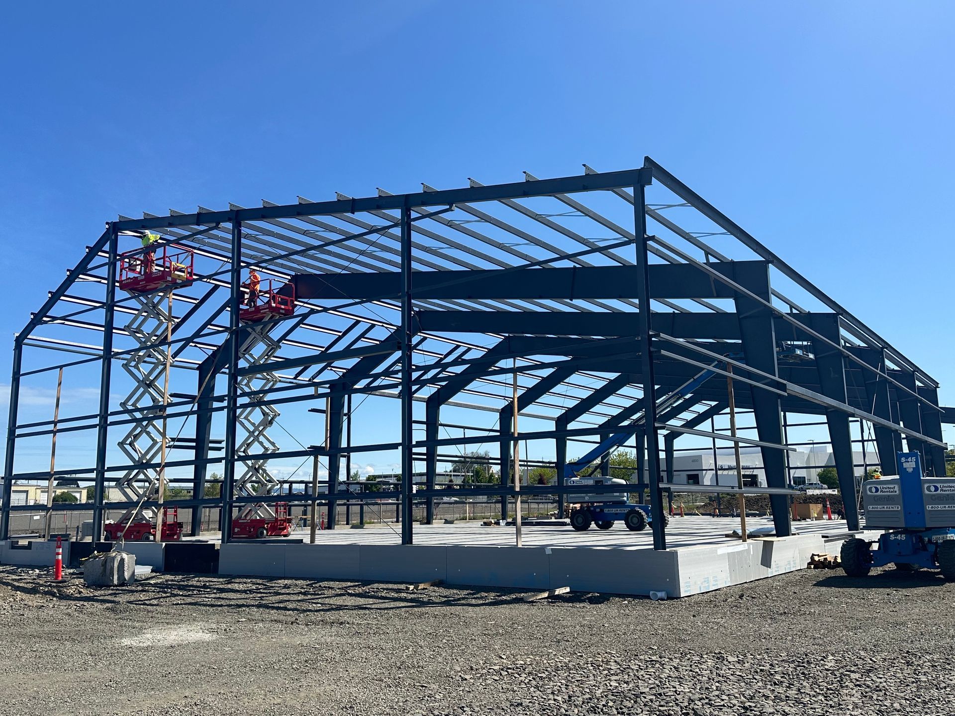Steel framework of a building against a blue sky with white clouds. 