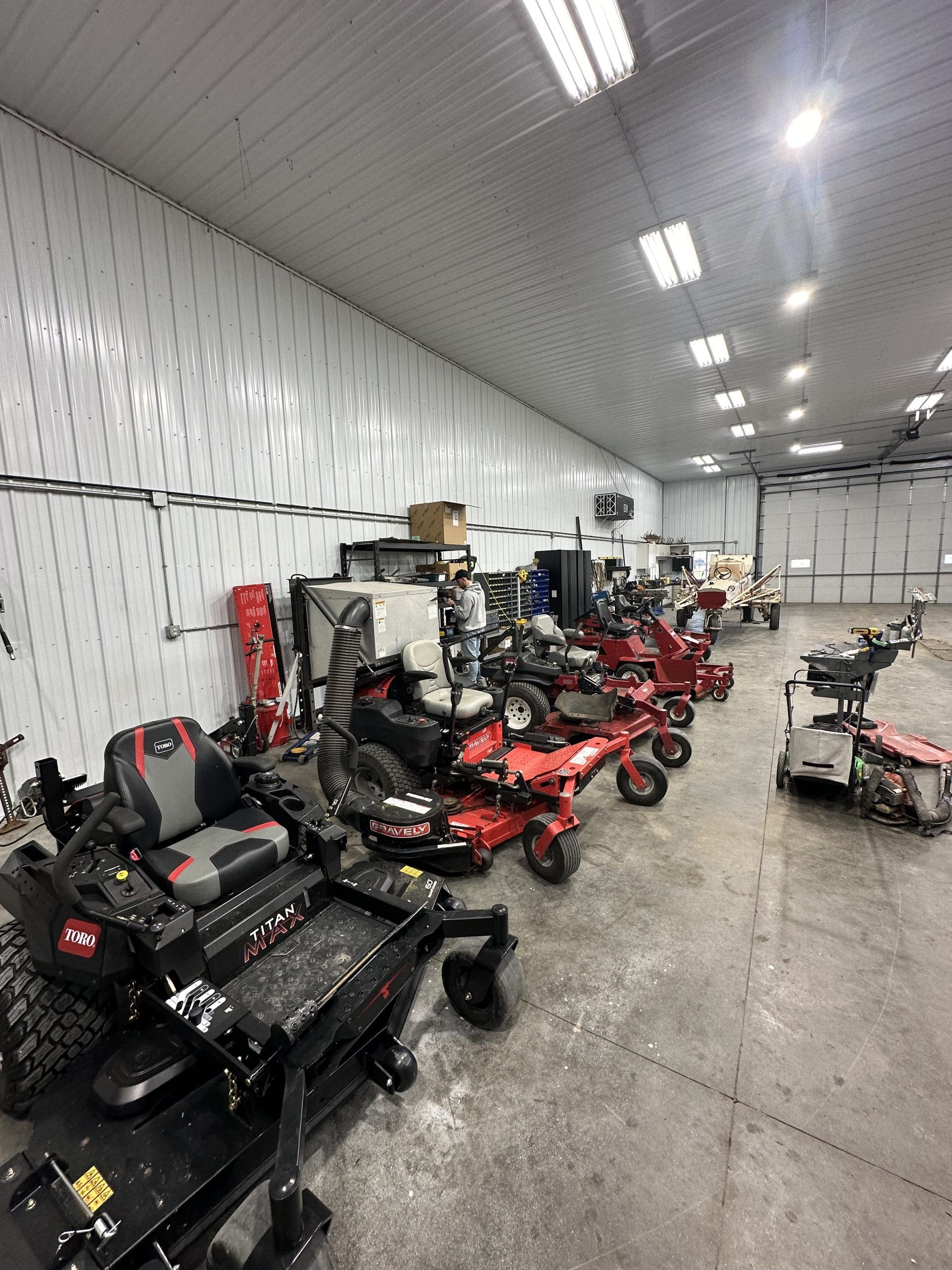 A large warehouse filled with lawn mowers and snow blowers.