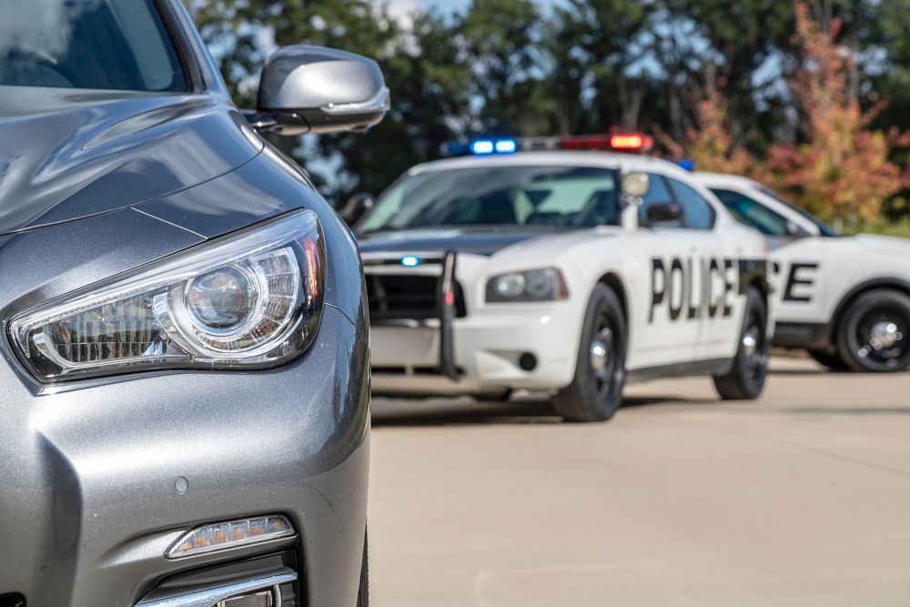 Two police cars are parked next to each other on the side of the road.