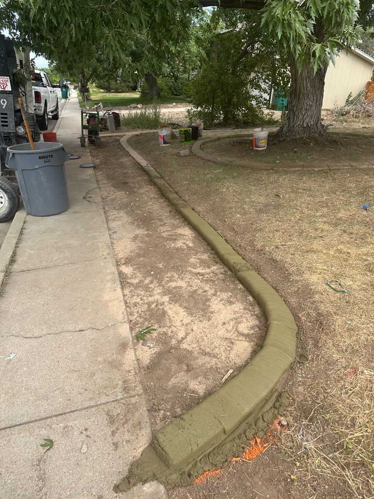 Newly poured concrete curb alongside a sidewalk in a residential area.