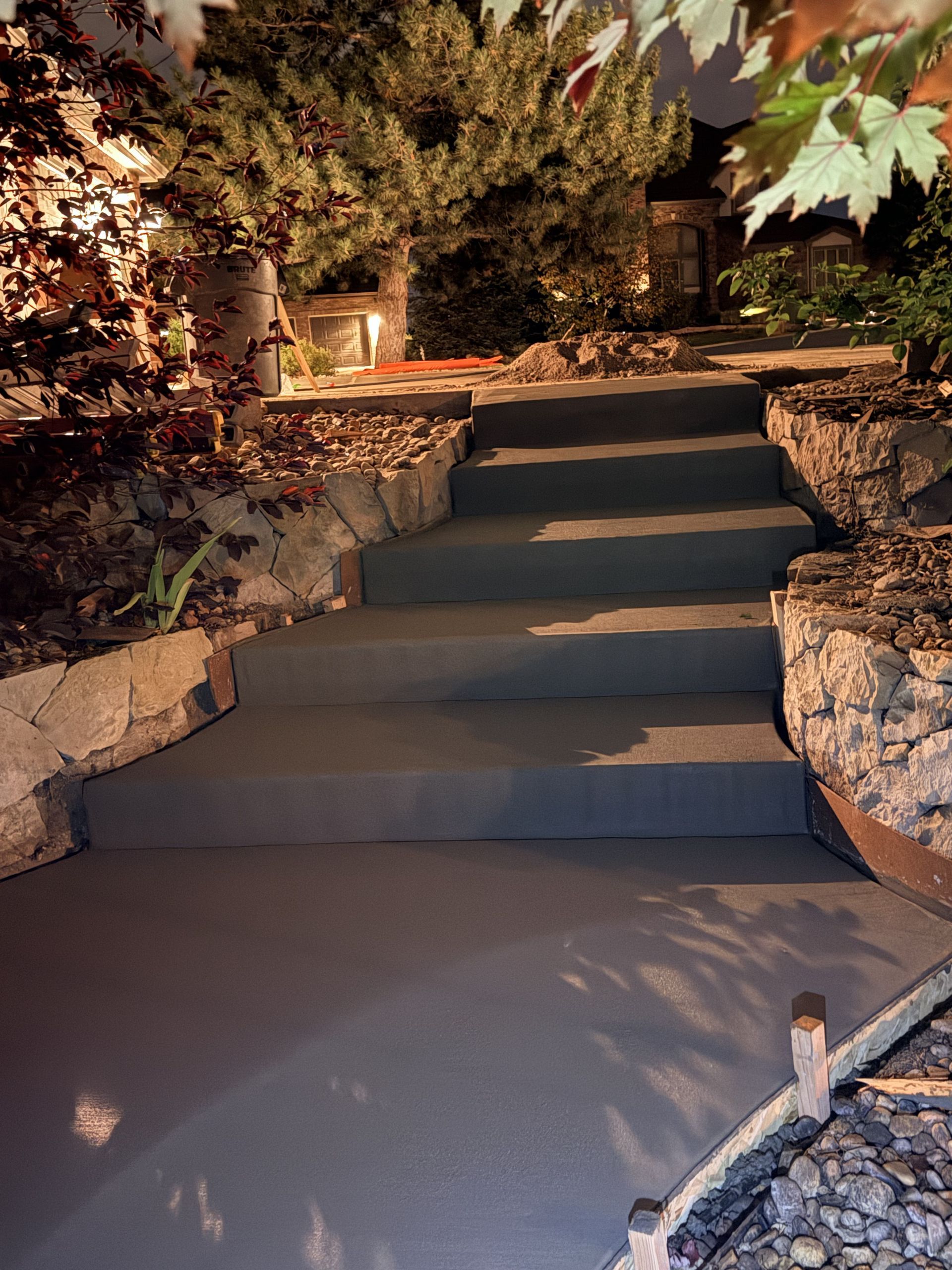 Newly poured concrete driveway, gray surface, with expansion joints.