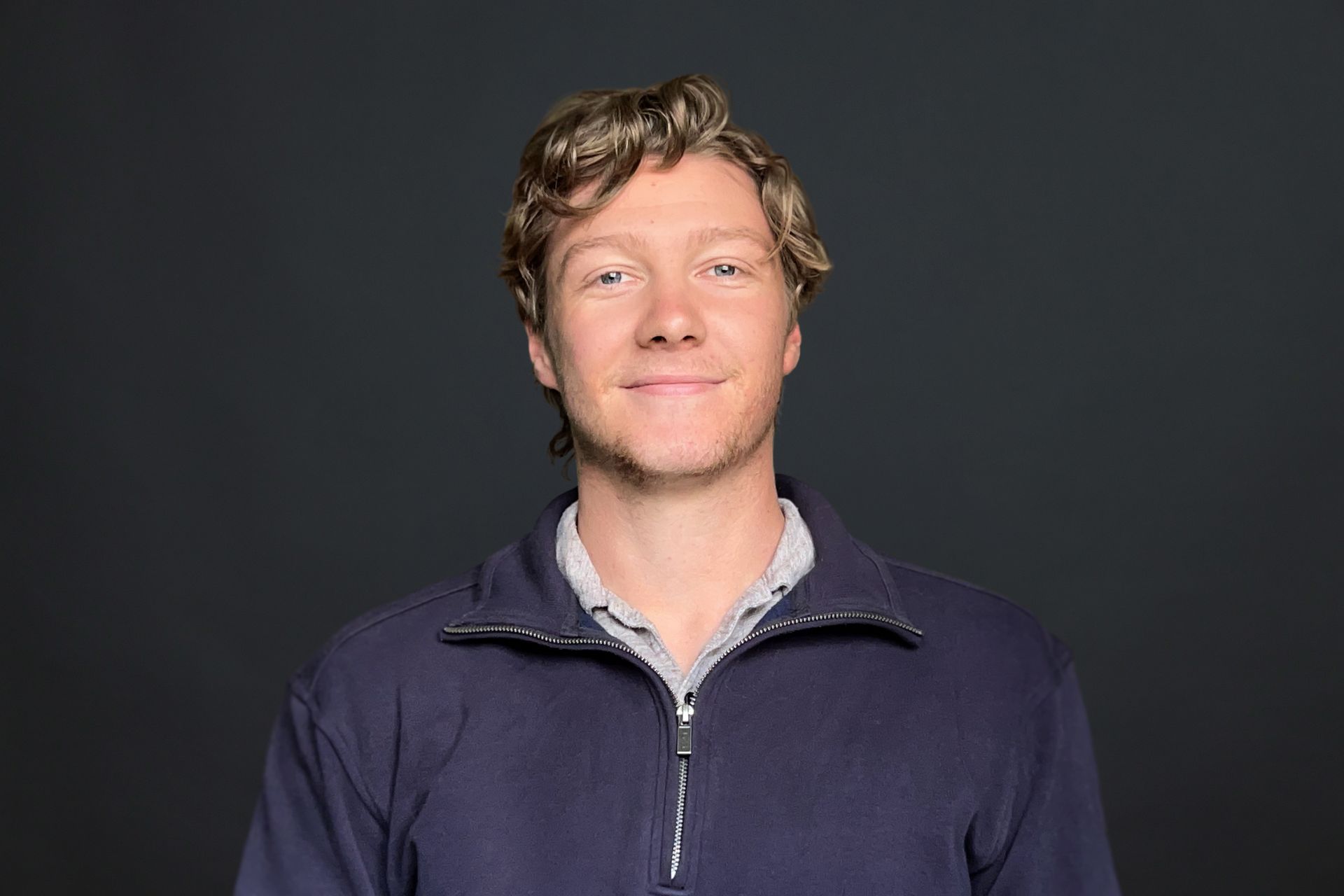 A man in a blue jacket is smiling for the camera.