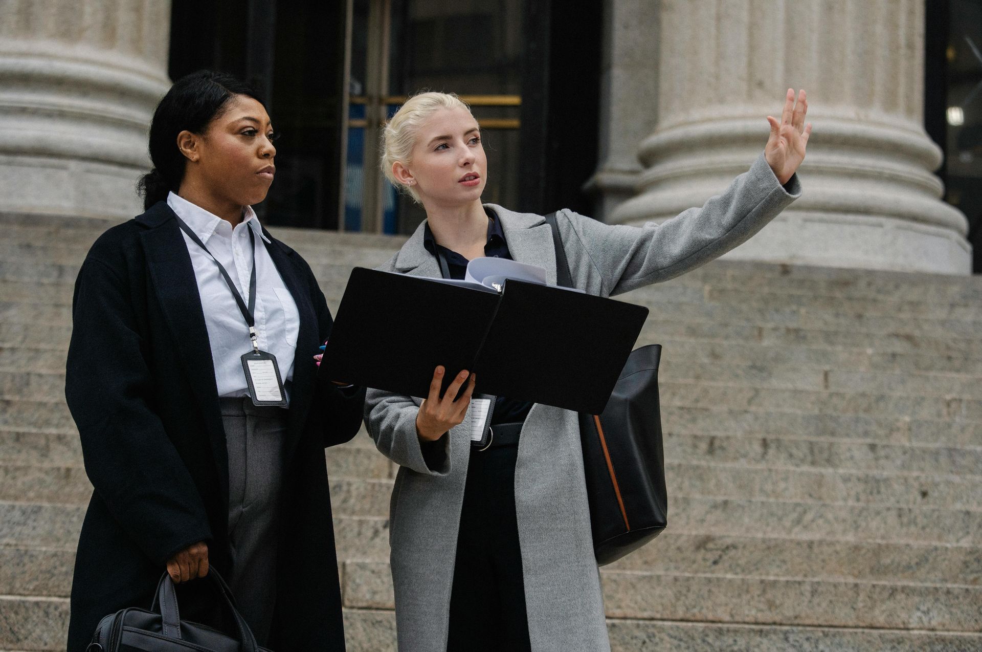 Two women are standing on a set of stairs in front of a building.