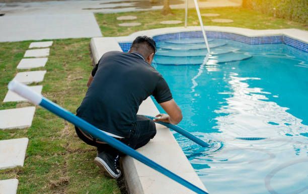 Pool service technician working poolside.