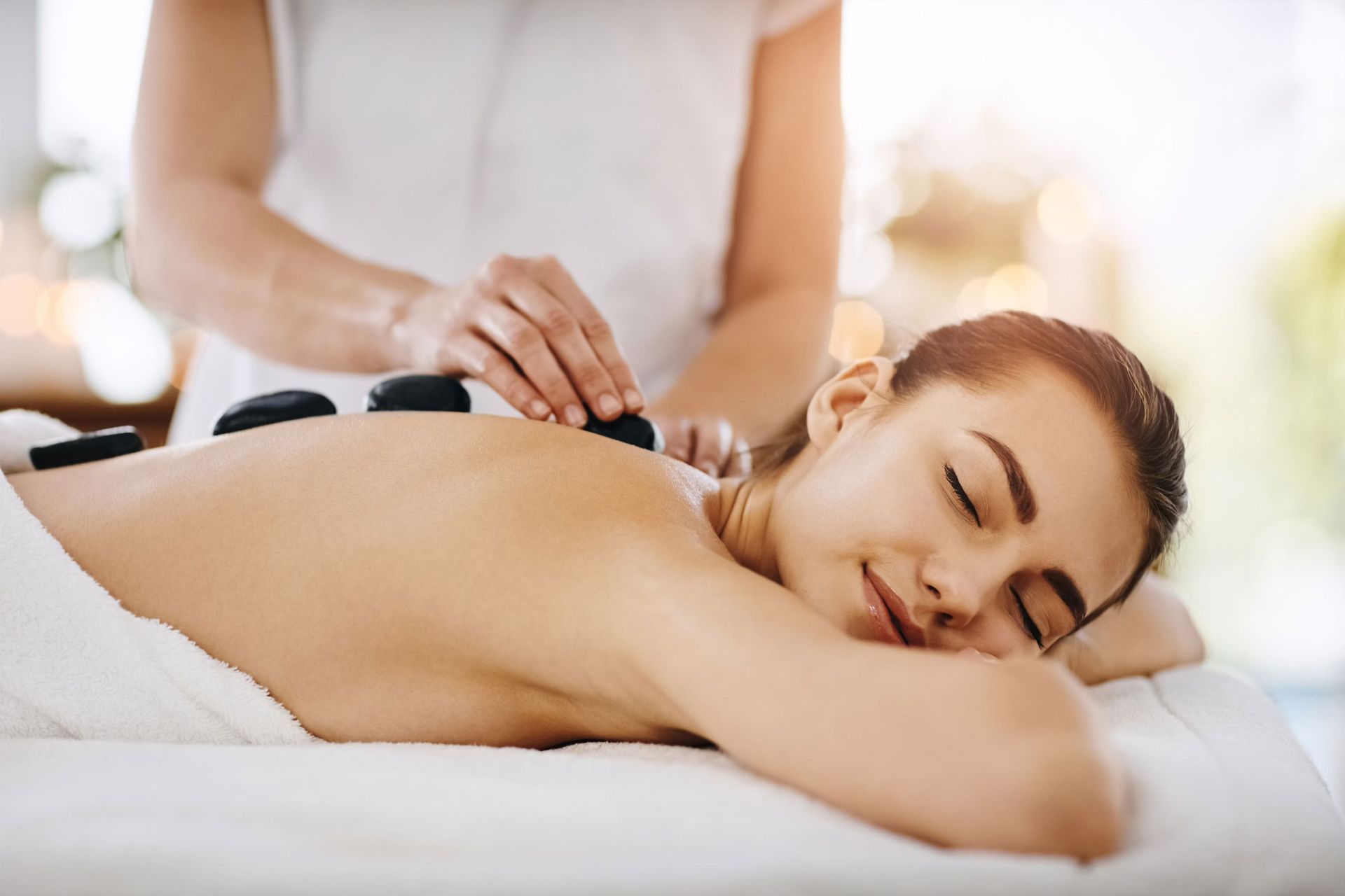 Woman Getting Hot Stone Therapy — Pompano Beach, FL — Pompano Beach Spa