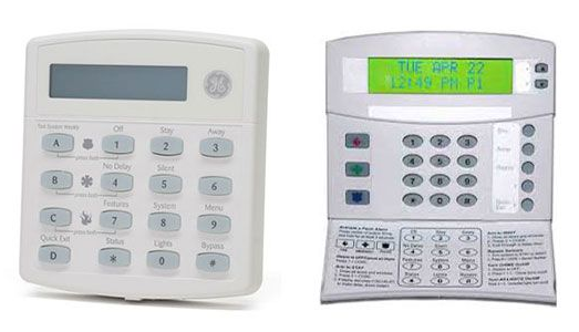 Two white home security system keypads with numerical buttons and displays.