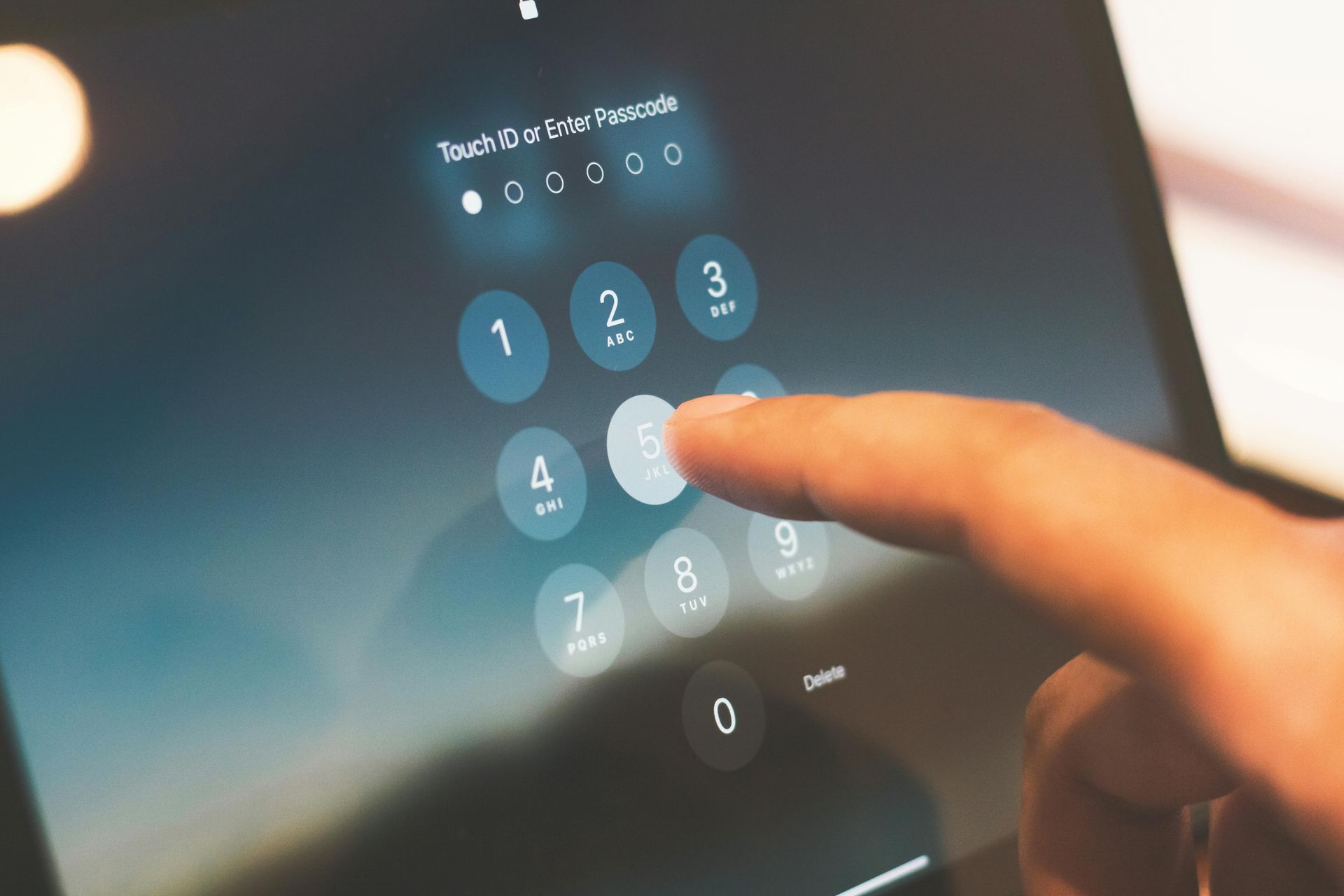 Finger entering a PIN on a tablet screen, numbers and Touch ID visible.
