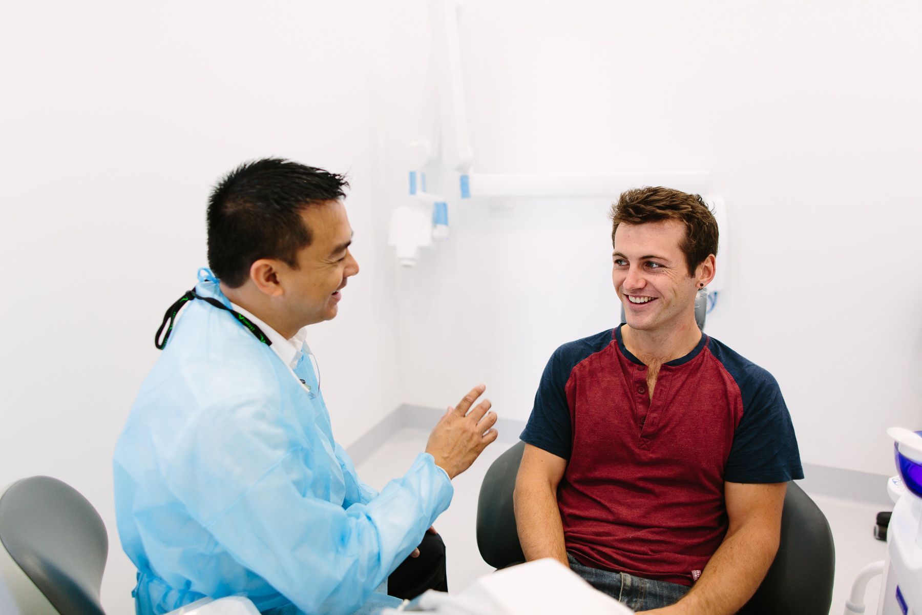 A Dentist is Talking to a Patient in a Dental Chair — New Leaf Dentists in Erina, NSW