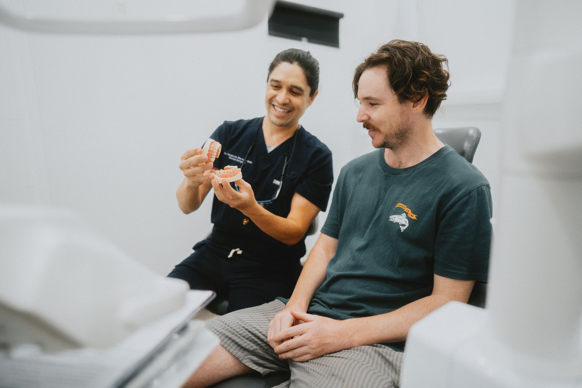 Dentist Showing Dental Model to Patient in a Dental Office, Both Smiling — New Leaf Dentists In Erina, NSW