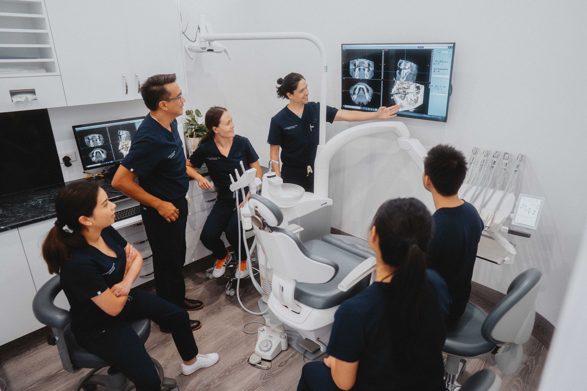 Dental Team Reviewing X-rays, Gathered Around a Dental Chair — New Leaf Dentists In Erina, NSW