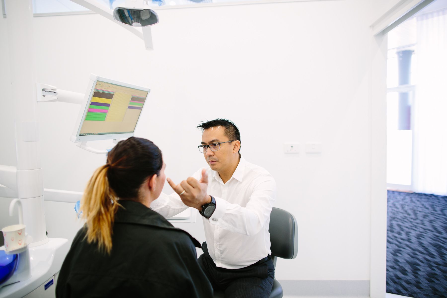 A Dentist is Talking to a Patient in a Dental Office — New Leaf Dentists in Erina, NSW