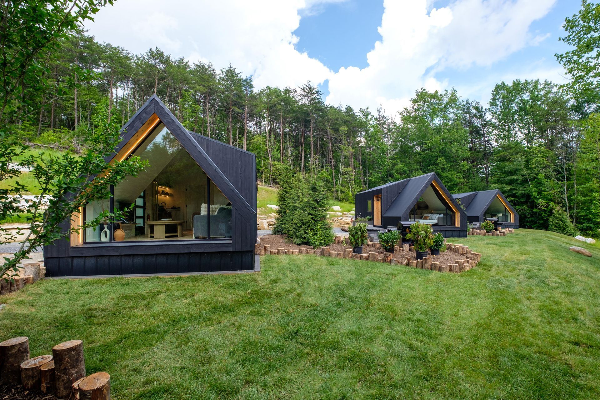 A large house with a large lawn in front of it is surrounded by trees.