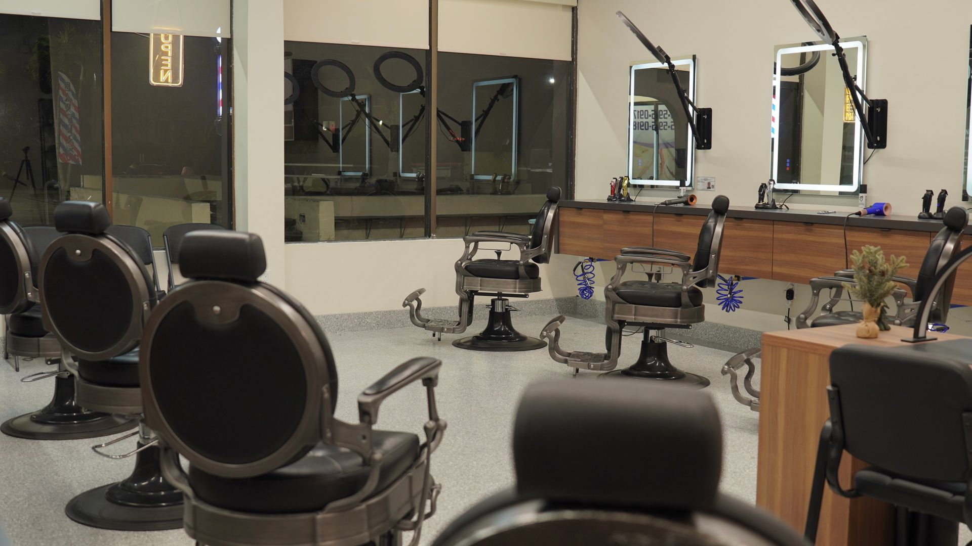 Hair salon interior with barber chairs, mirrors, and a neutral color palette.