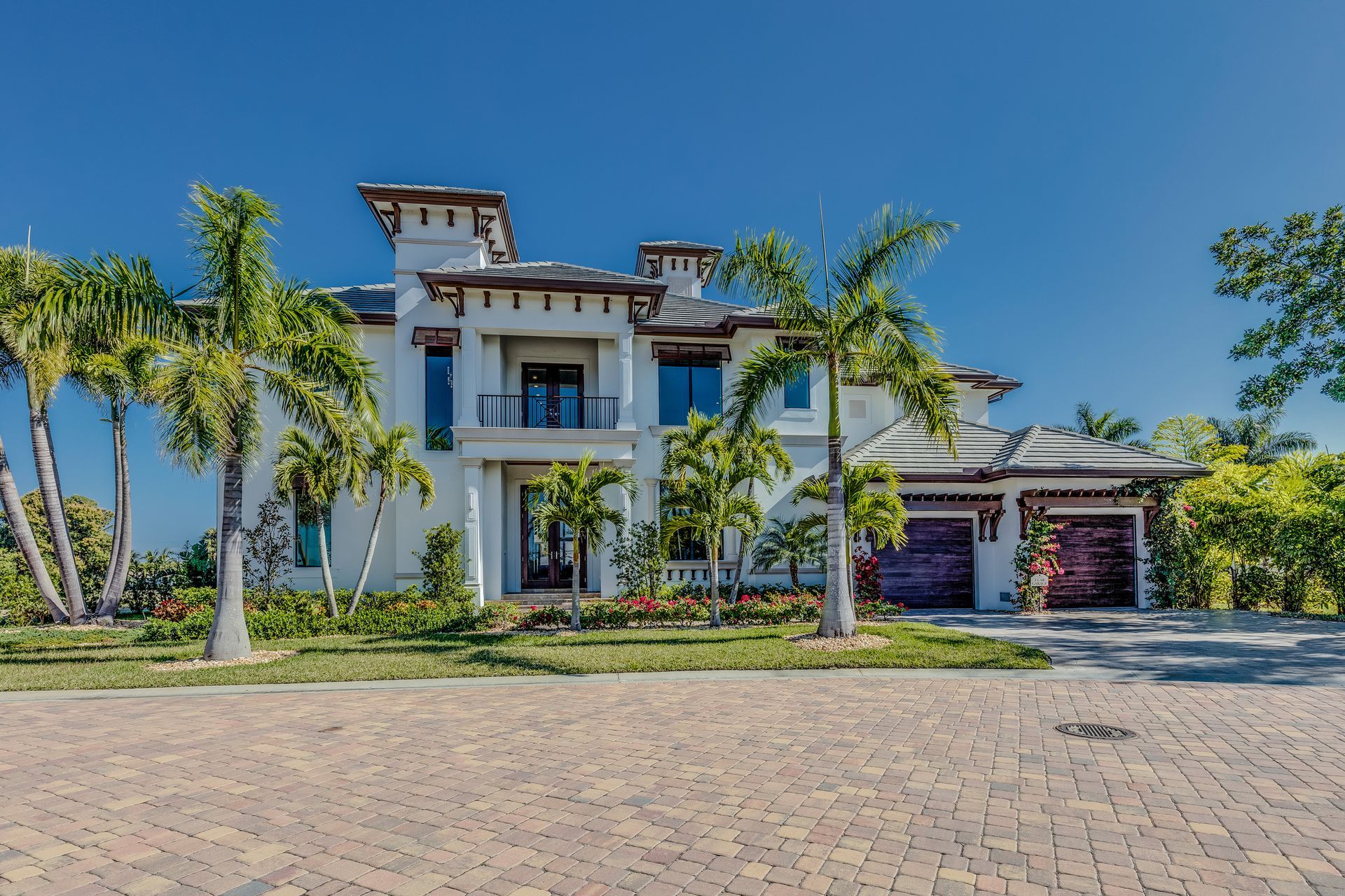 Luxury white stucco house with palm trees and a blue sky. Luxury white stucco house with palm trees and a blue sky.