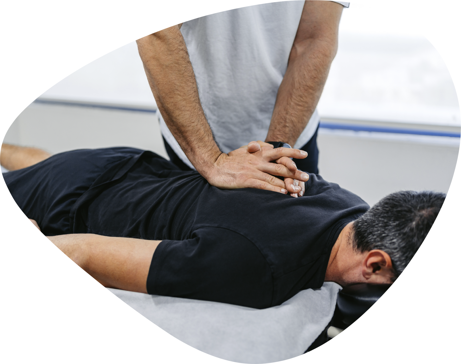 A man is laying on a table getting a massage from a doctor.