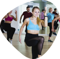 A group of people are doing exercises in front of a mirror.