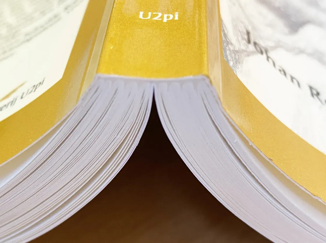Open boek met gele kaft en witte pagina's, gezien vanaf de bovenste middenvouw.