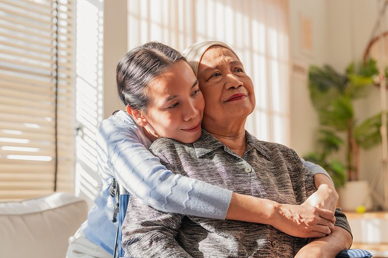 A woman who is facing cancer receives a hug from her daughter.