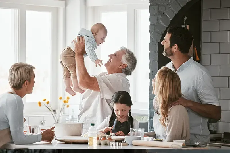 A family enjoys multigenerational living as they spend time together in the kitchen.