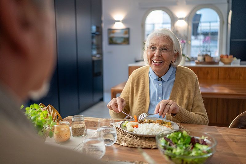 A woman who has overcome senior appetite changes enjoys a healthy meal.