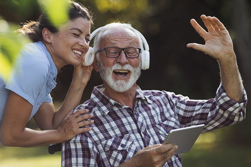 A caregiver who has learned how to make hard things easier for someone with dementia listens to music with the man in her care.