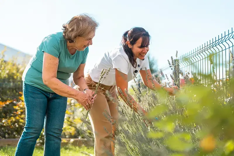 A young woman helps her mother with gardening, knowing that how Mom spends her time after retirement is important to her sense of self-worth.