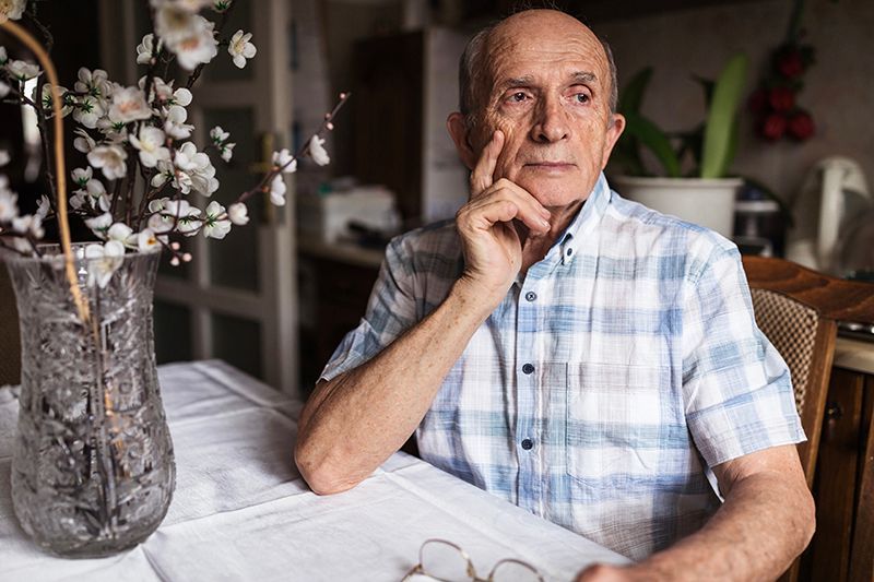 A man experiencing pica, a common issue for those with dementia, sits at his dining room table.