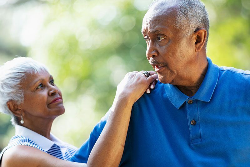 A woman comforts an older man who has been displaying unexpected dementia behaviors.