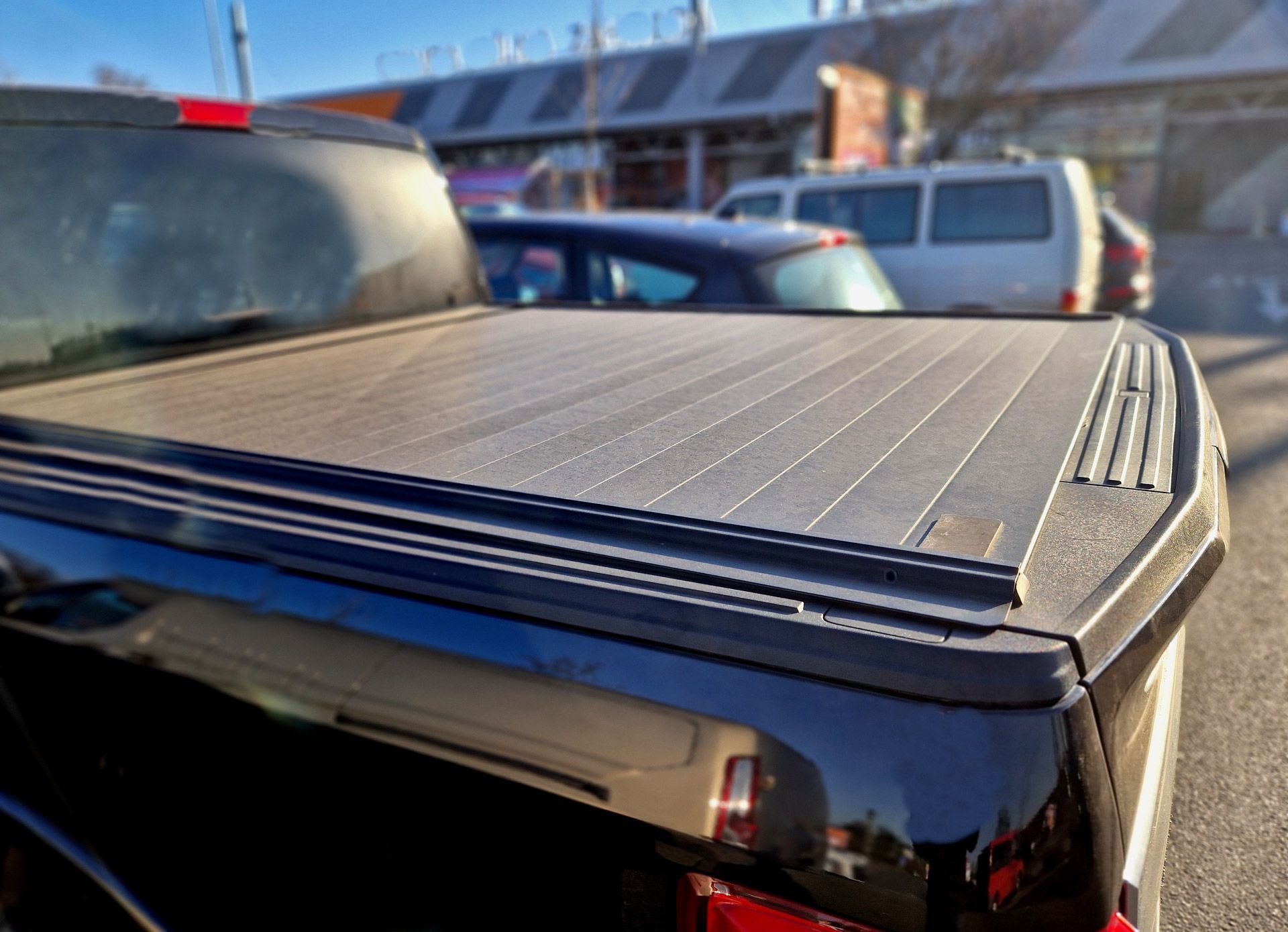 A black truck bed cover with a tailgate locking system designed to fit the vehicle.