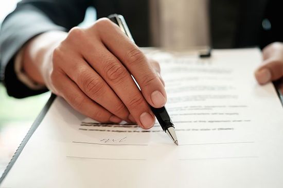 amministratore indica dove firmare il contratto con una penna