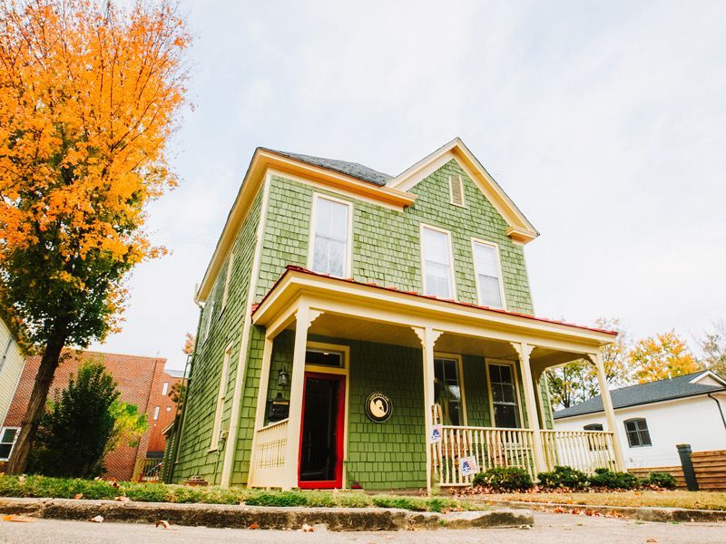 a green house with a red door is Simpson Law's office building