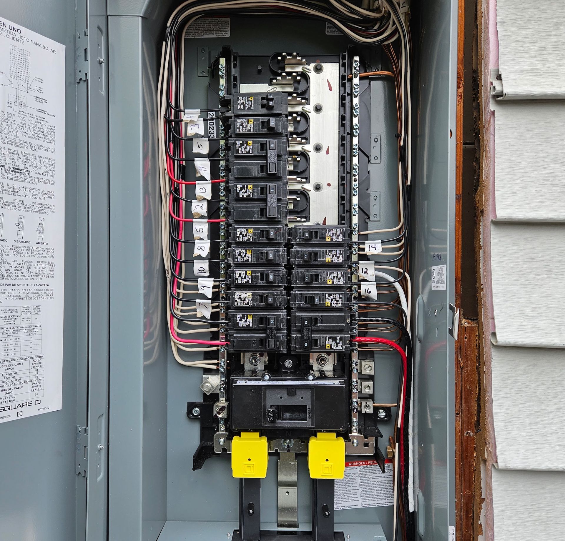 Electrical panel with circuit breakers and wiring.
