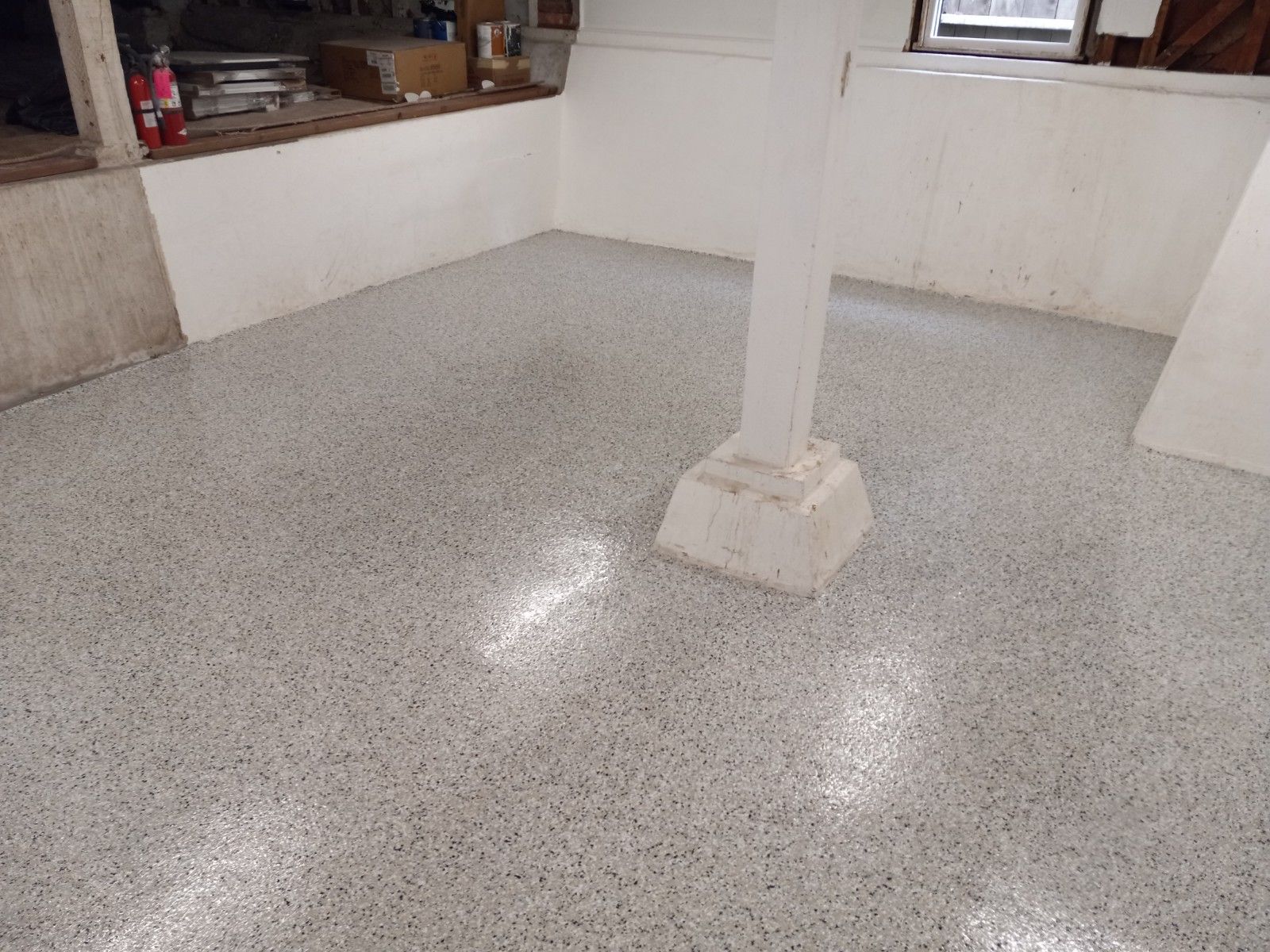 Two men are standing in an empty room with black walls