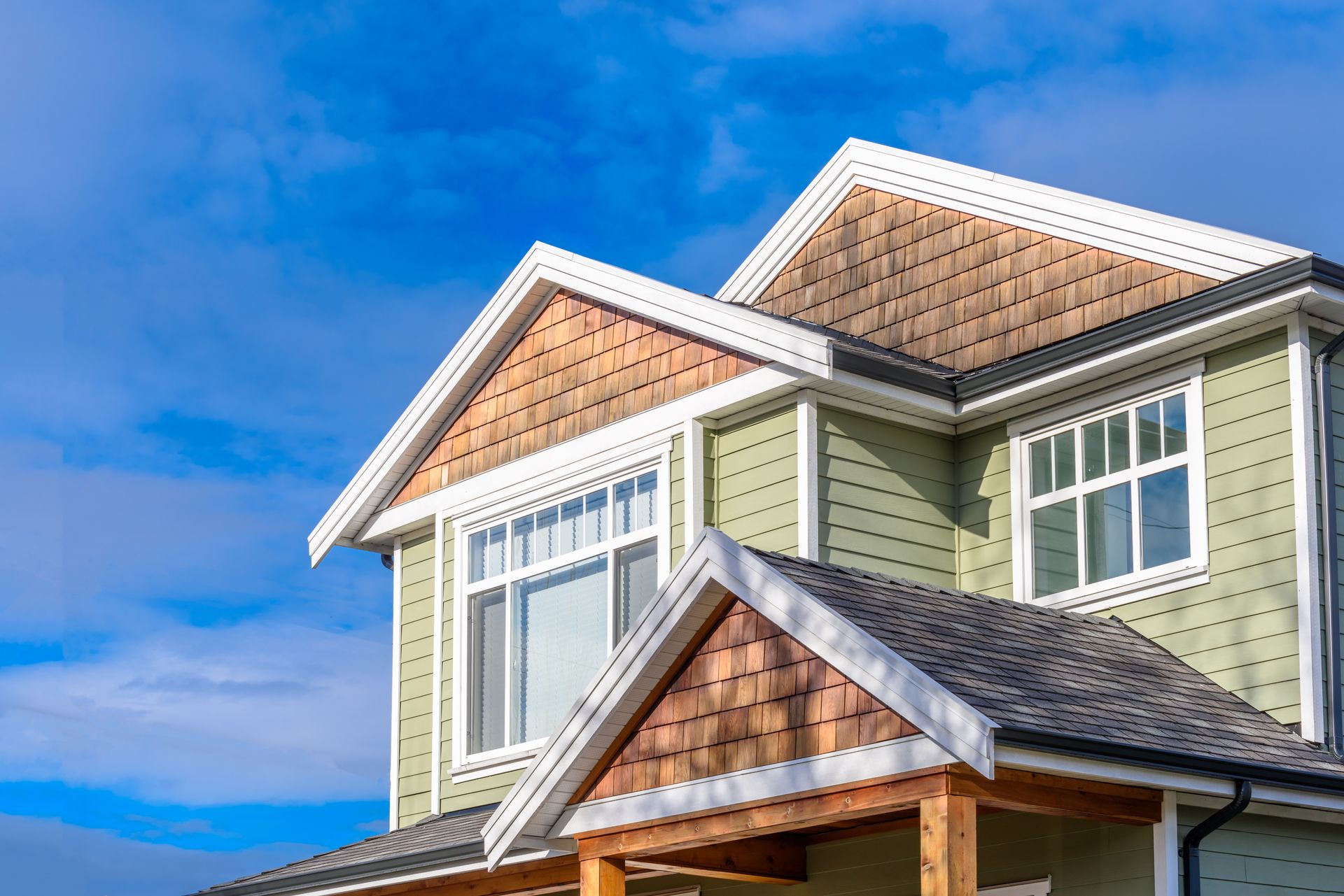 Brick building with a cupola on a college campus, surrounded by greenery and other buildings.