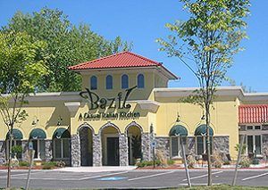 Basil restaurant with yellow exterior, red roof, and arched entrance.