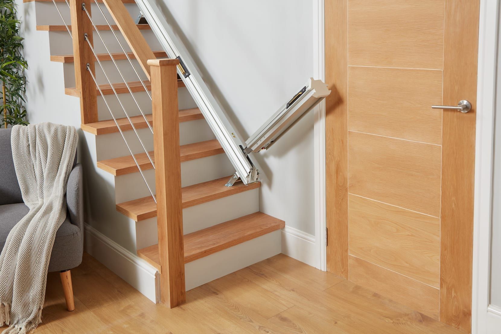 Indoor staircase with wooden steps, metal handrails, and a closed wooden door beside it.