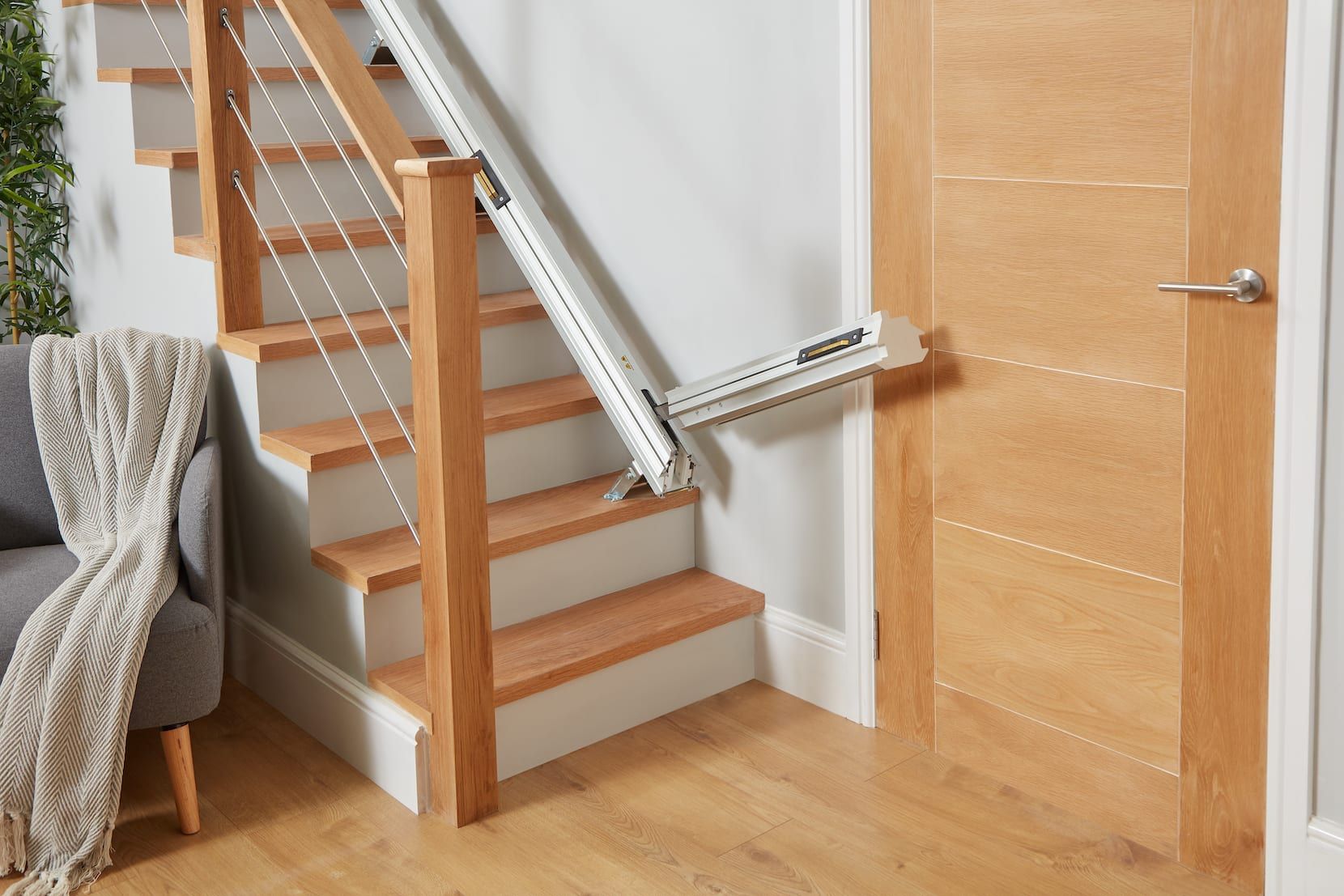 Stairlift installed beside a wooden staircase in a bright home interior
