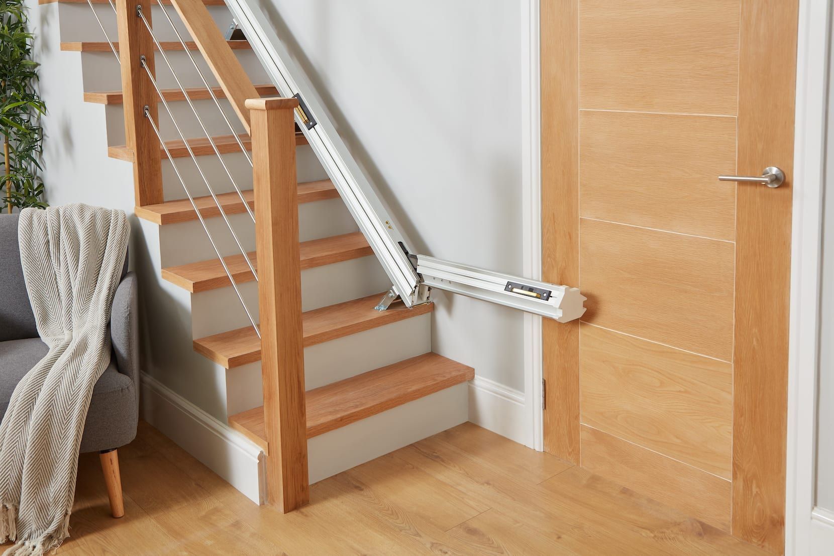 Stairlift installed beside a wooden staircase in a home interior.