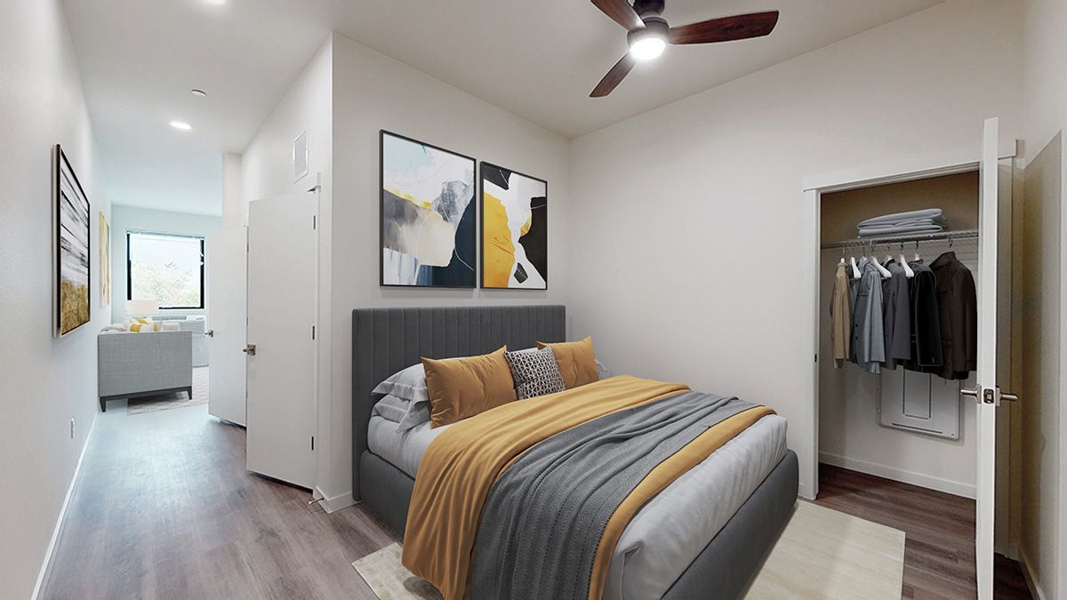 Bedroom with bed, closet, art, and hallway. Neutral walls, wood-look floor, and ceiling fan.