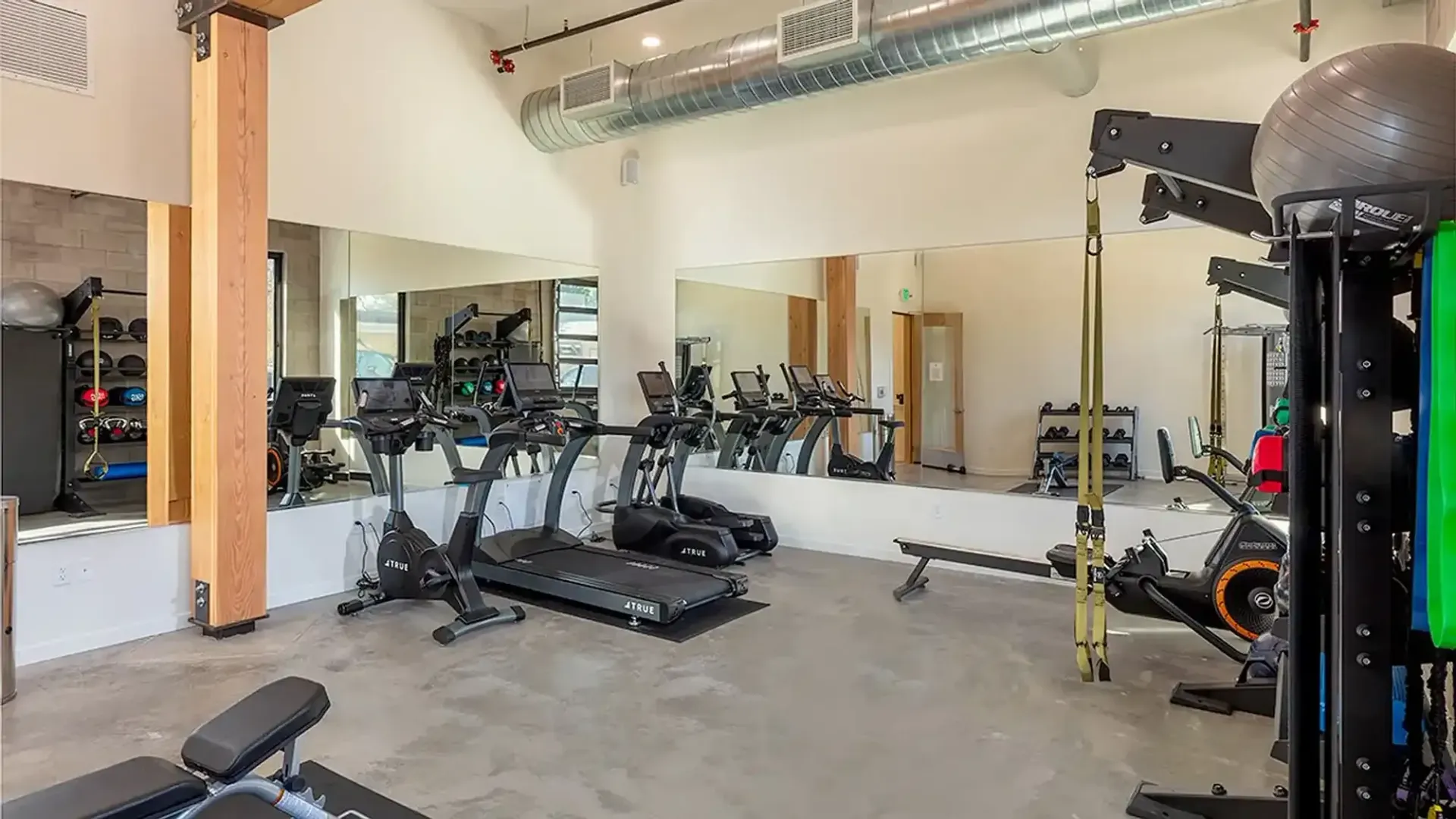 Gym interior with treadmills, mirrors, and workout equipment.