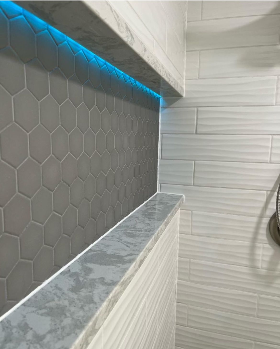 A bathroom with a shower head and a shelf.