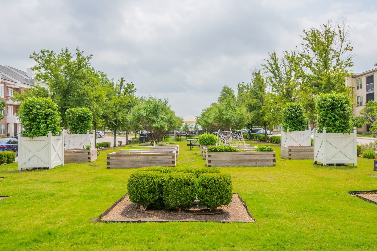 Outdoor community courtyard with planters, trees, and benches in a residential complex.